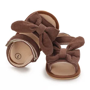 Detailed view of brown corduroy baby girl sandals with large decorative bow