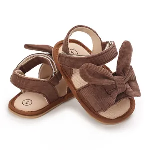 Close-up detail of brown corduroy baby girl summer sandals featuring a cute decorative bow