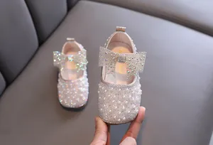 Detailaufnahme von Prinzessinnenschuhen für Mädchen mit Perlen und Strassschleife