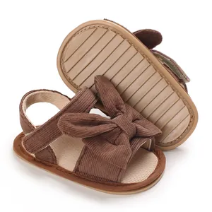 Close-up of brown corduroy baby sandals with bow decoration and anti-slip sole