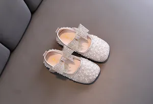 Nahaufnahme von Prinzessinnenschuhen für Mädchen mit glitzerndem Strass und Perlen.