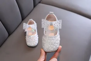 Detailaufnahme von funkelnden Mädchen Prinzessinnenschuhen mit Strass und Schleife.