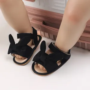 Close-up detail of cute black corduroy bow baby girl sandals for infant summer wear
