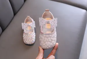 Nahaufnahme der funkelnden Strass-Schleifendekoration auf eleganten rosa Mädchen-Prinzessin-Schuhen