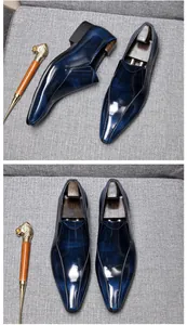 Detailed top view of men's glossy navy blue leather loafers on textured background