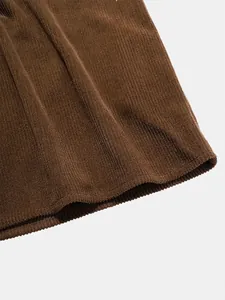 Macro view of brown corduroy fabric texture and hem detail for men's short sleeve polo shirt