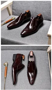 Detailed view of burgundy patent leather slip-on loafers on a grey textured surface