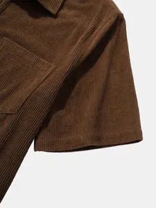 Macro view of the soft brown corduroy fabric and stitching on a men's polo shirt