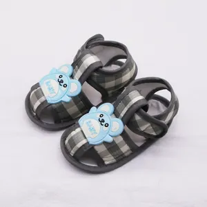 Primer plano de sandalias de verano para bebés con suelas blandas y detalles de ositos