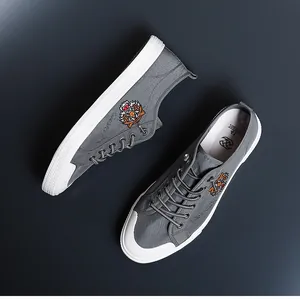Gros plan sur des chaussures en toile grises pour hommes avec broderie tigre