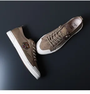 Détail des baskets basses respirantes pour hommes avec un motif de tigre brodé