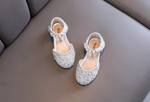 Détail de chaussures de princesse argentées pour filles avec strass et perles