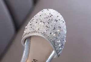 Gros plan de strass étincelants et de perles sur des chaussures argentées pour filles