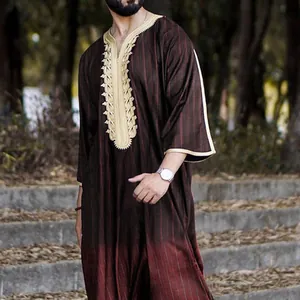 Detailed macro shot of a men's traditional kaftan with gold embroidery and stripes