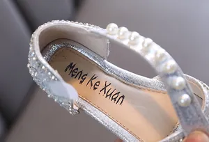 Gros plan détaillé de chaussures de princesse argentées à paillettes avec perles pour fille