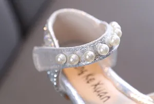 Gros plan détaillé sur chaussures de princesse argentées avec bride perlée pour fille