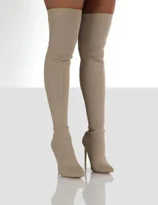 Close-up detail of beige thigh-high knit stiletto boots with elegant pointed toe design