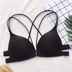 Dettaglio reggiseno nero senza ferretto con spalline sottili incrociate e chiusura frontale.