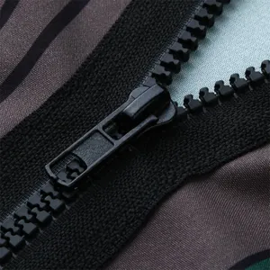 Close-up detail of a durable black resin zipper on a men's striped hooded robe garment