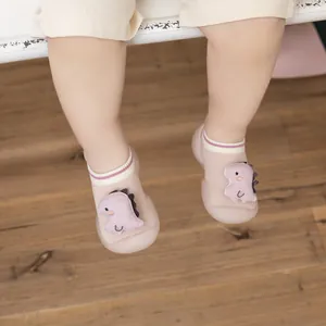 Detail view of infant non-slip walking sock shoes with cute dinosaur character decor