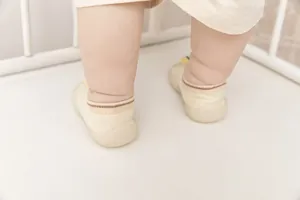 Rear view of baby wearing beige silicone soft sole non-slip floor socks shoes