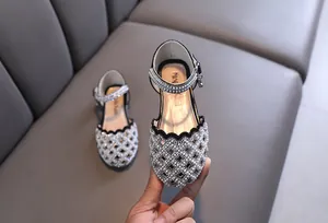Elegant girls hollow sandals decorated with pearls and rhinestones close-up detail view