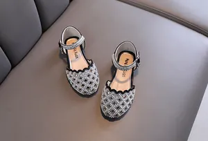 Detail of girl's black princess shoes featuring rhinestone hollow-out design