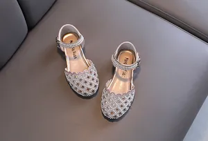 Detailed view of champagne pink princess shoes with pearl and rhinestone hollow-out design