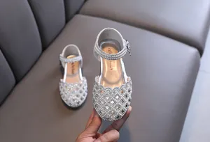 Close-up of silver princess shoes for girls with elegant pearl and rhinestone hollow-out detail