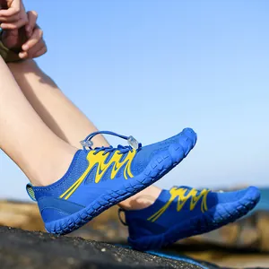 Blue and yellow quick-dry water shoes for swimming and hiking shown on a rocky beach.