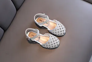 Detail of silver girls princess shoes featuring sparkling rhinestones and hollow lattice pattern