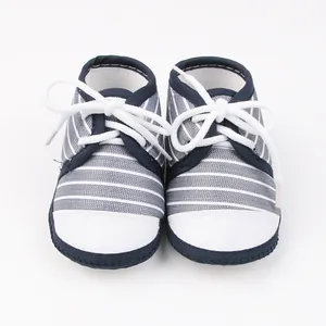 Vooraanzicht van gestreepte marineblauwe en witte babyloopschoenen met zachte zolen.