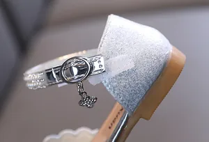 Close-up view of silver princess shoes for girls featuring a pearl strap and clover charm