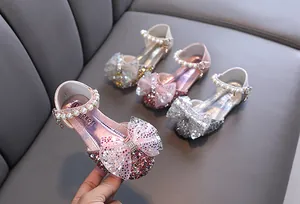 Detalle de zapatos de princesa con purpurina para niñas con perlas y lazos elegantes