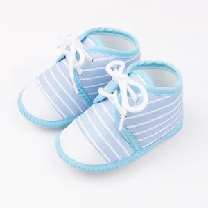 Detailopname van lichtblauw gestreepte babyschoentjes met zachte zolen en witte veters