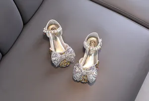 Vista detallada de zapatos de princesa para niña con gran lazo de purpurina y perlas