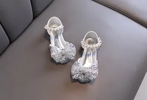 Vista detallada de zapatos de princesa plateados con purpurina y correa de perlas