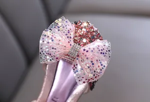 Primer plano de un lazo de tul rosa con estrellas en zapatos de princesa con purpurina