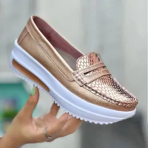 Vista detallada del mocasín de plataforma oro rosa con textura de serpiente y suela