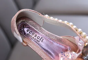 Primer plano de zapatos de princesa rosa brillantes con perlas y lazo detalle