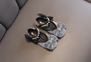 Top view detail of sparkly silver girls princess party shoes with oversized bow and pearls