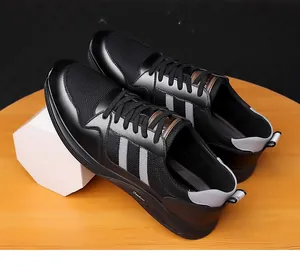 High-angle detailed shot of men's black mesh elevator sneakers on a wooden display table