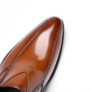 Close-up of brown leather dress shoes with decorative stitching on pointed toe