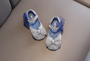 Detail view of blue glitter princess shoes with decorative pearls and bows for girls.