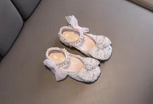Elegant sparkly girls princess shoes with pearls and bows for dance performance.