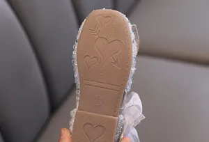 Close-up of heart-patterned anti-slip rubber sole on glitter girls princess flat shoes