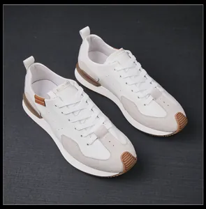 Vista lateral detallada de zapatillas de cuero blanco con detalles de ante beige