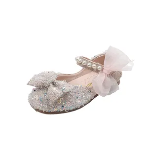 Detailed macro view of pink sequined girls princess dress shoes with pearl strap and bow