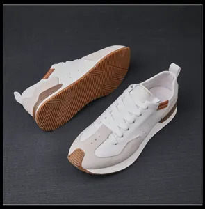 Primer plano de zapatillas retro de cuero blanco para hombre con suela de goma duradera.
