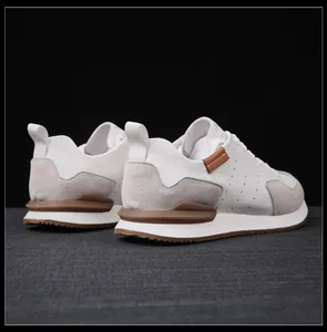 Vista trasera detallada de zapatillas de cuero blanco premium con detalles de ante gris